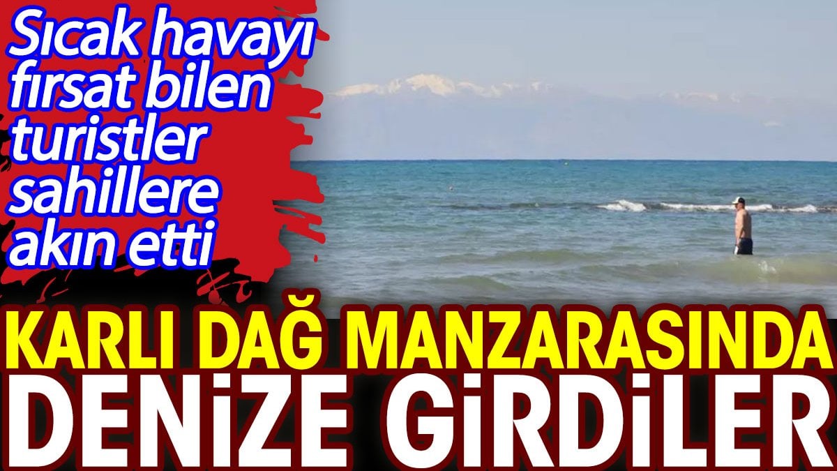 Karlı dağ manzarasında denize girdiler. Sıcak havayı fırsat bilen turistler sahillere akın etti