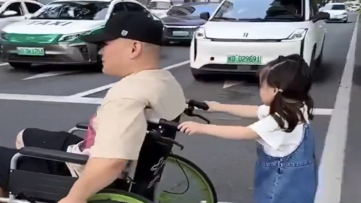 Küçük kızın tekerlekli sandalyedeki babasına yol veren raçlara teşekkürü