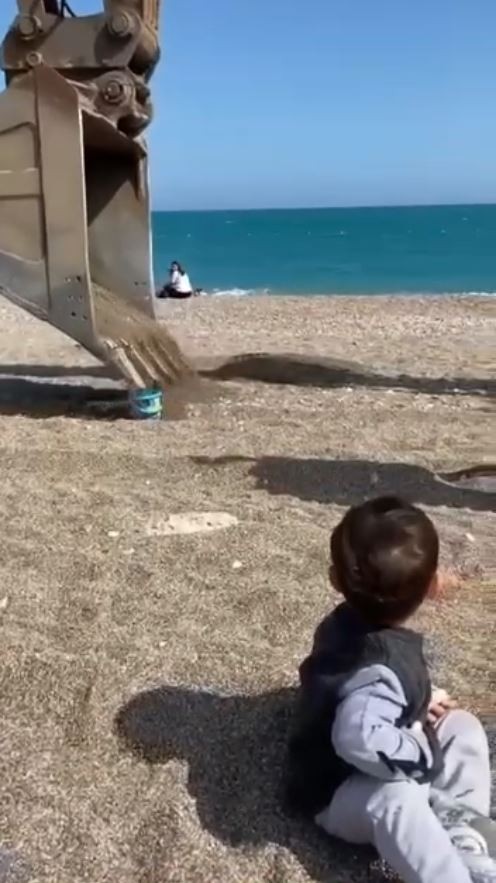 Sahilde oynayan çocuğun kum kovasını iş makinesi doldurdu