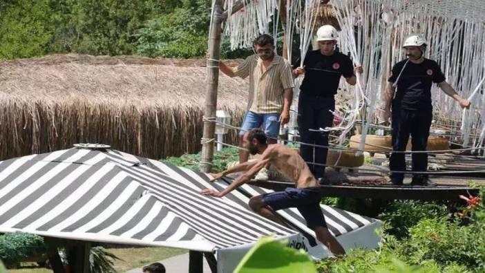 Antalya'da Tarzan adam alarmı. Polislerden kaçıp şemsiyenin üstüne çıktı
