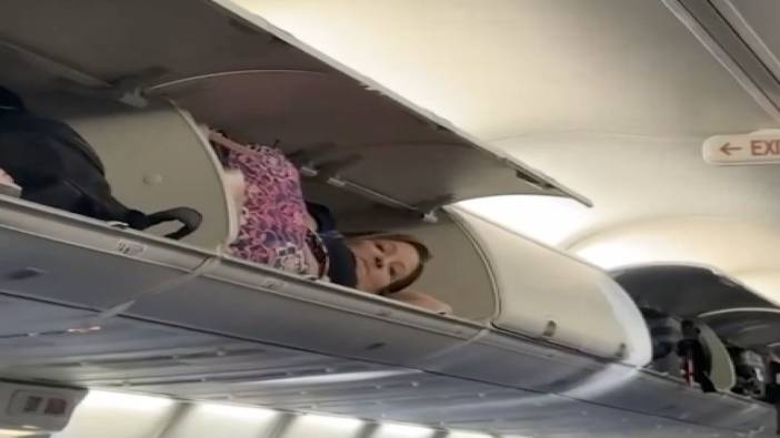 Uçakta ilginç görüntü: Bir yolcu valiz dolaplarına çıkarak uyumaya çalıştı