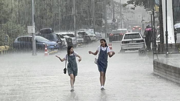 Sağanak yağış bastırınca yağmurda oynayarak serinlediler