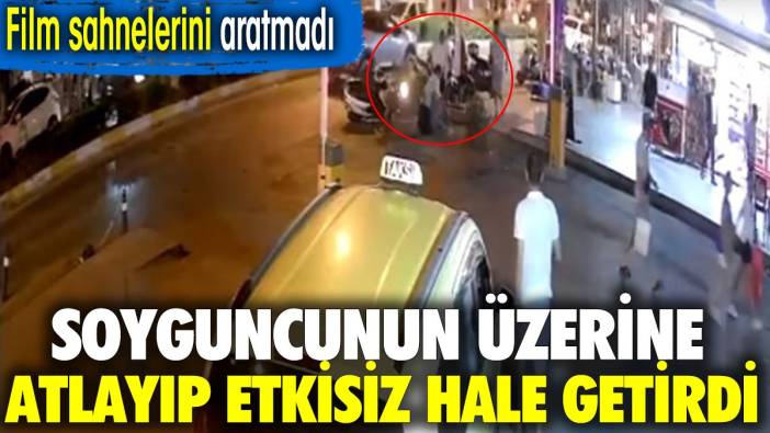 Soyguncunun üzerine atlayıp etkisiz hale getirdi. O anlar kamerada