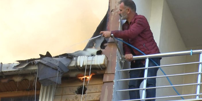 Alev alev yanan çatıya balkonundan bahçe hortumu ile müdahale etti