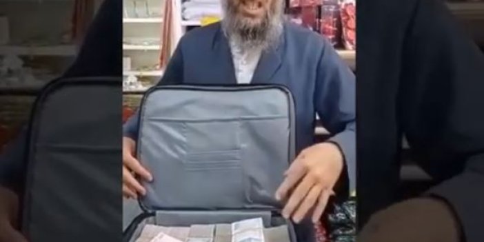 Türkiye çantasının içi tıka basa dolar dolu olan takkeli sakallı kişiyi konuşuyor. Çantanın içini açıp paraları gösteriyor