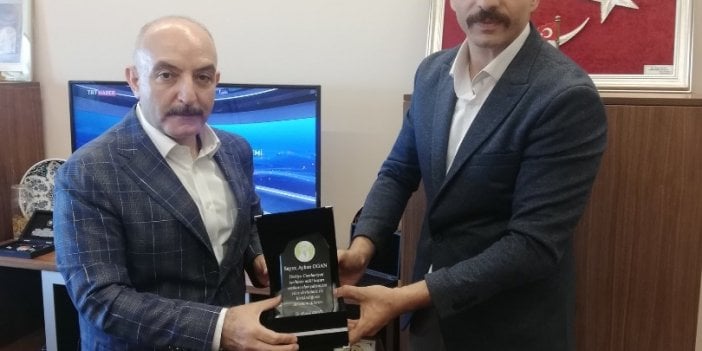 Mustafa Yücel dün Prof. Dr. Esin Davutoğlu Şenol’u tehdit etmişti. Bugün Cumhurbaşkanı Danışmanı Ayhan Ogan’a plaket verdi