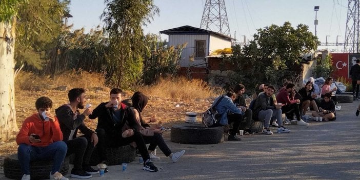 Öğrenciler lastiklerin üzerinde yemek yiyor. İzmir Büyükşehir Belediyesi'nin öğrencilere ücretsiz yemek vermesine rektör kapıları kapattı