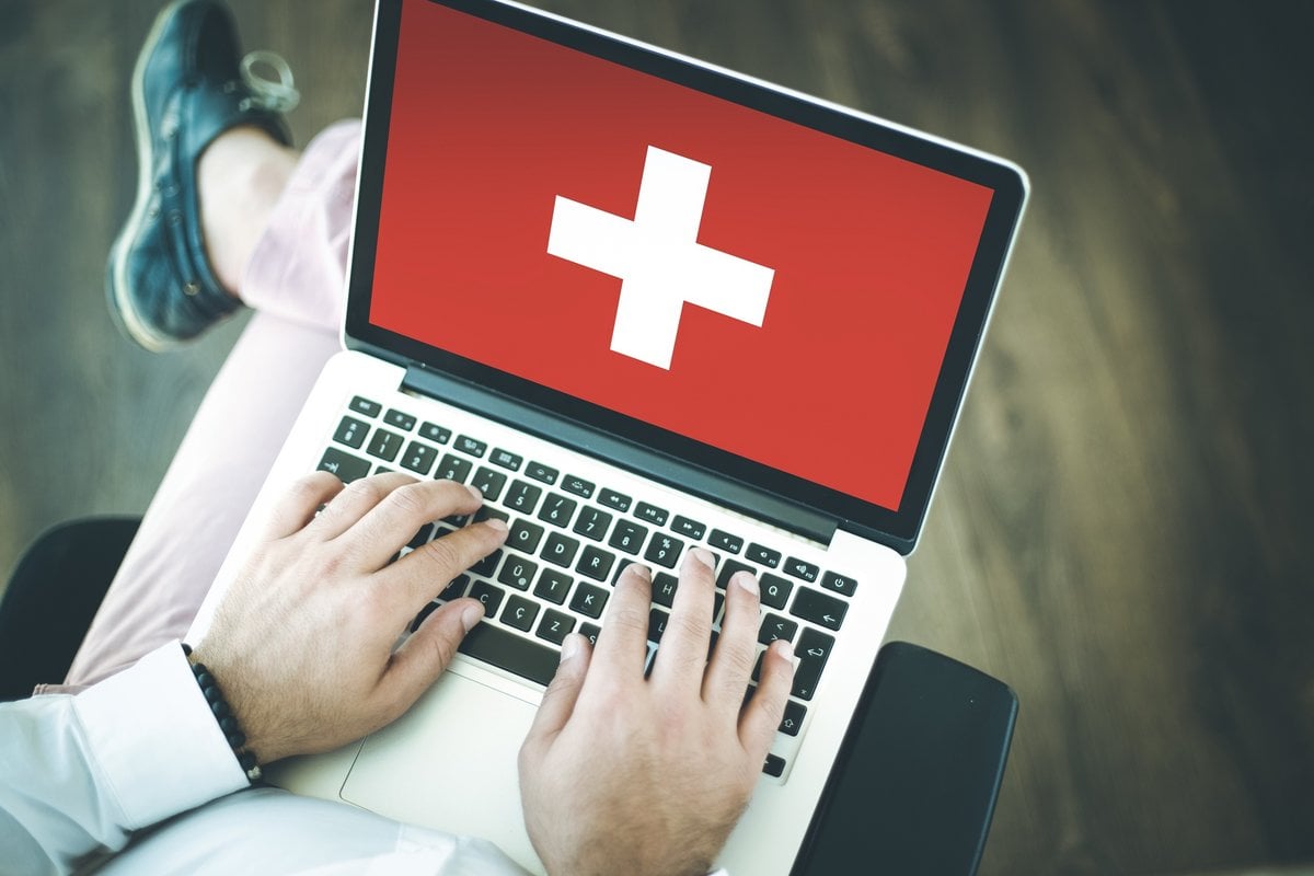 swiss-flag-and-man-working-on-a-laptop.jpeg