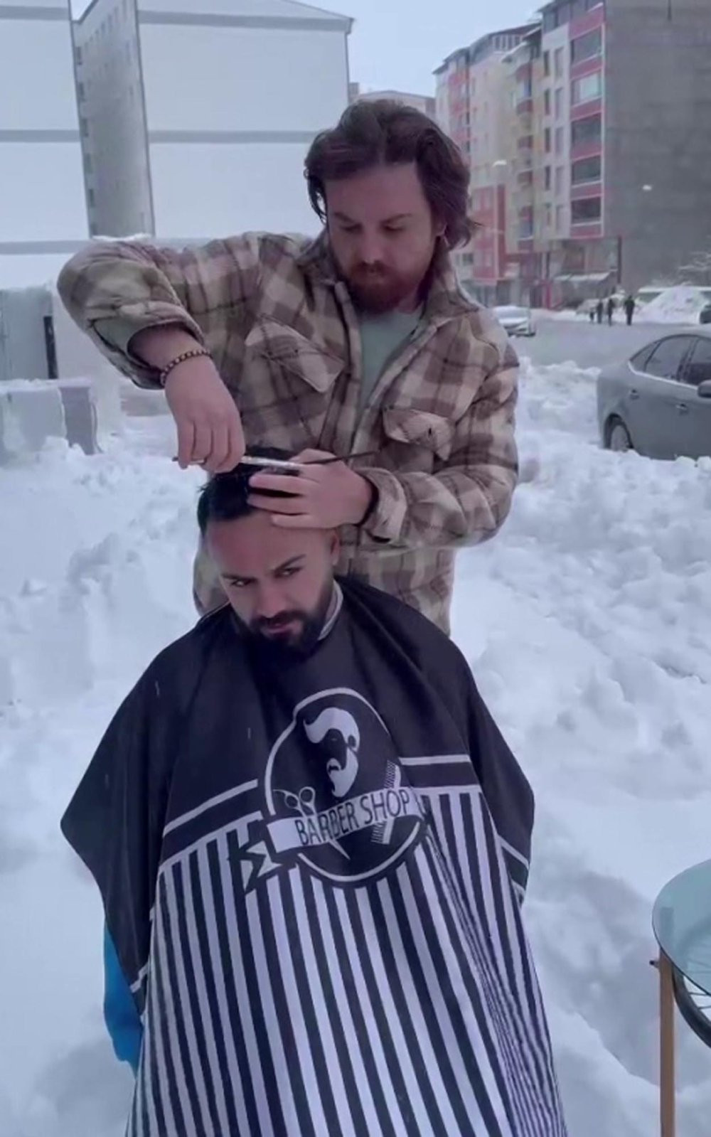Berber, müşterilerini karlı havada, tıraş etti